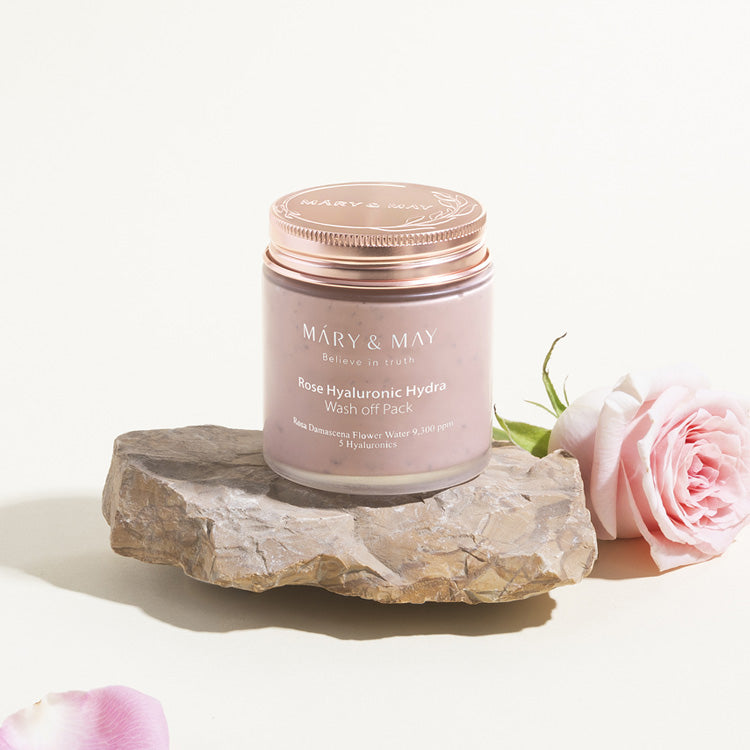 MARY & MAY Rose Hyaluronic Hydra Wash off Pack 125g on stone with pink rose beside
