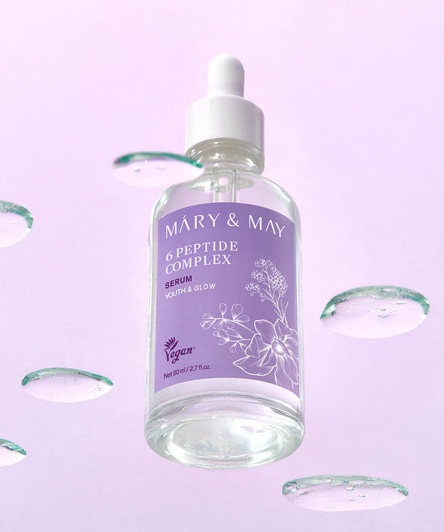 Bottle of MARY&MAY 6 Peptide Complex Serum 80ml against a soft purple background with water droplets.