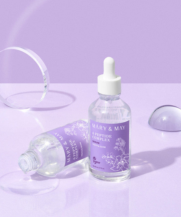 MARY&MAY 6 Peptide Complex Serum 80ml bottle on a purple surface, featuring peptide-rich formula for skincare.
