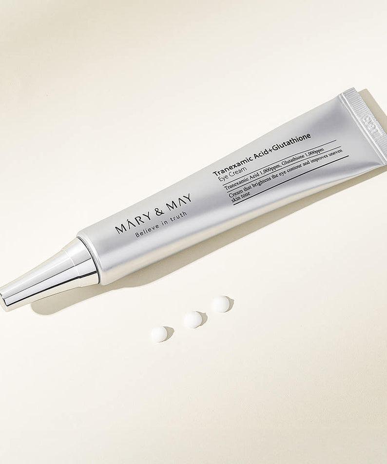 MARY&MAY Tranexamic Acid Glutathione Eye Cream 30ml tube with product samples on a light background.