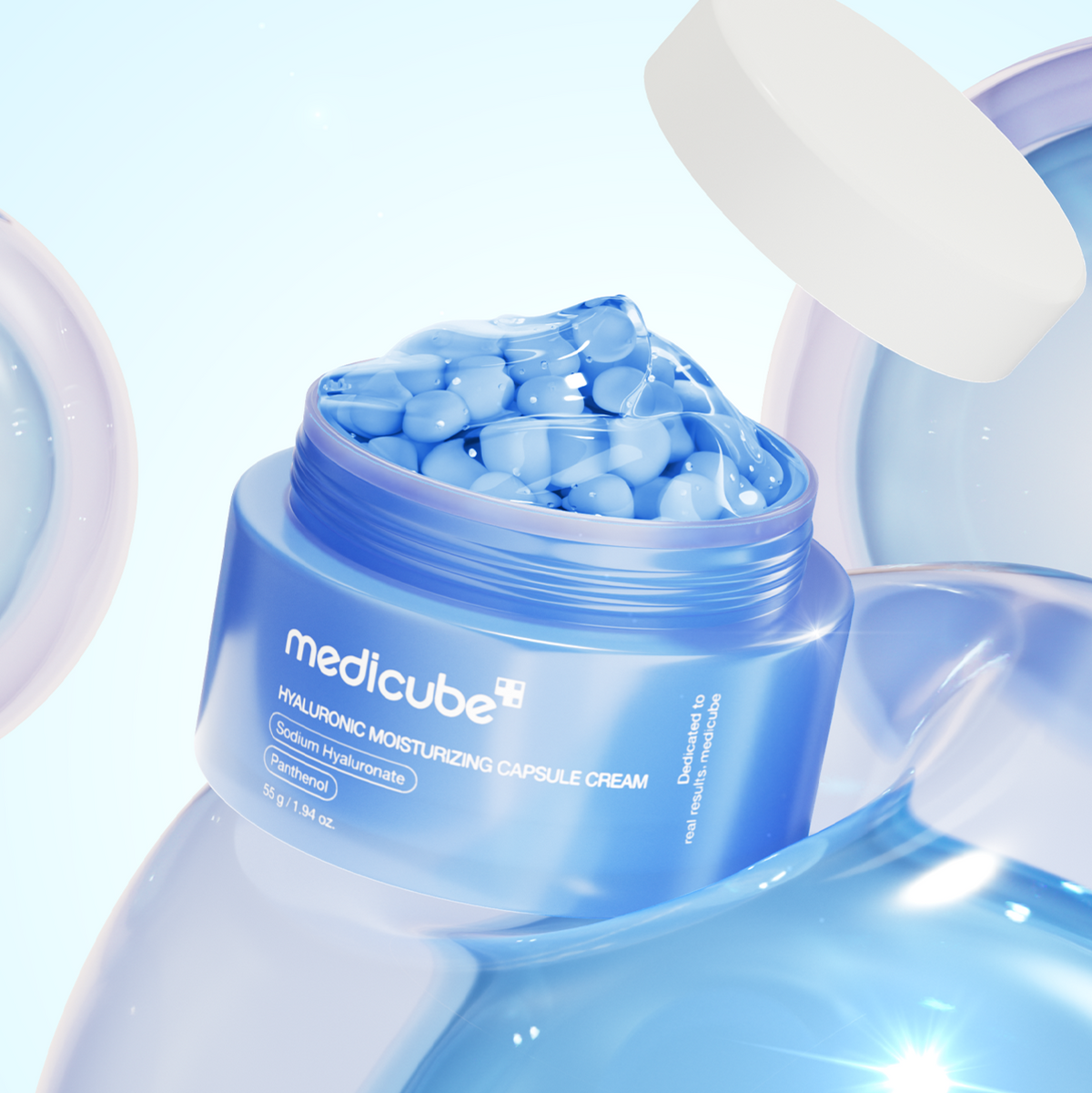 MEDICUBE Hyaluronic Moisturizing Capsule Cream 55g jar with blue capsules and lid, showcasing the product's design and hydrating formula.
