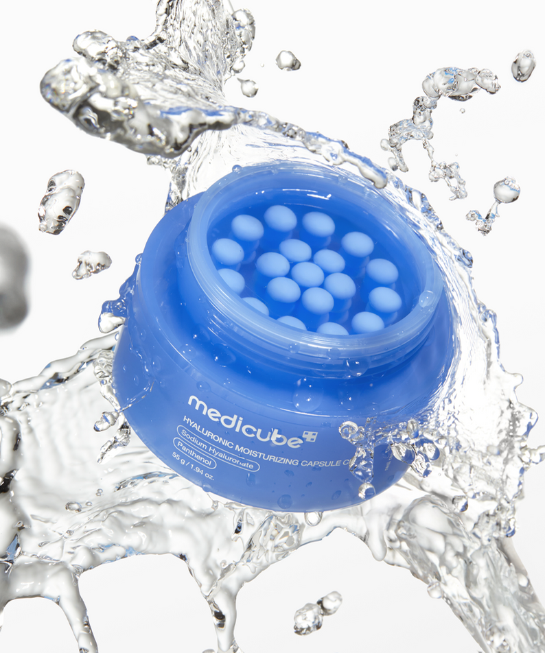 MEDICUBE Hyaluronic Moisturizing Capsule Cream 55g in a blue jar with water splash, showcasing texture and hydrating properties.
