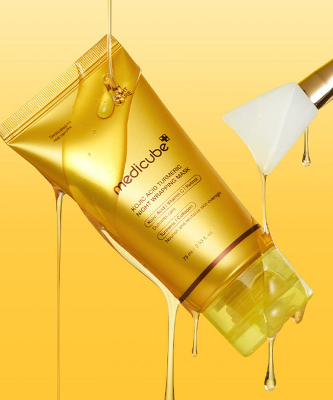 MEDICUBE Kojic Acid Turmeric Vita Wrapping Mask 75ml tube with dripping texture and spatula on yellow background.