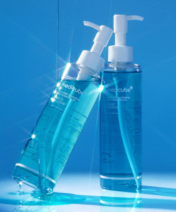 Two bottles of MEDICUBE Zero Pore Blackhead Deep Cleansing Oil 205ml with a vibrant blue background.