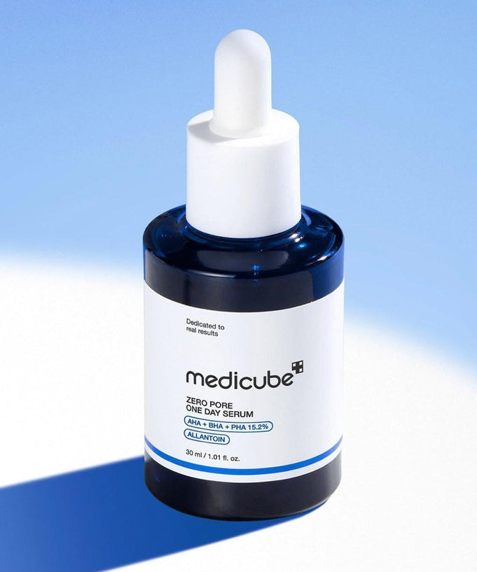 Close-up of MEDICUBE Zero Pore One-Day Serum 30ml against a blue background. Skincare product in white and blue packaging.