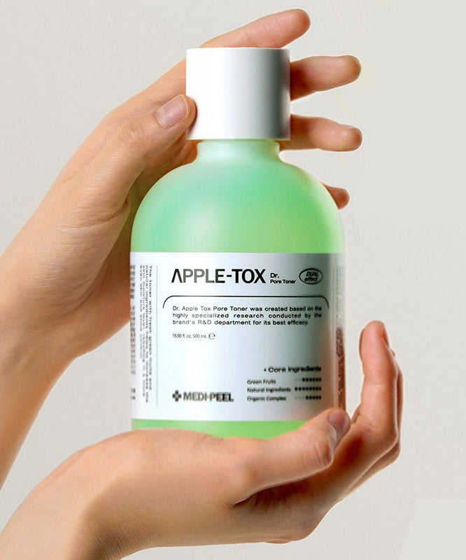 Hands holding MEDIPEEL Dr.Apple Tox Pore Toner 500ml bottle