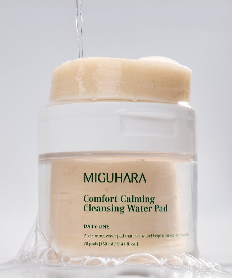 MIGUHARA Comfort Calming Cleansing Water Pads 70 Sheets in a clear container with cleansing water pouring down.