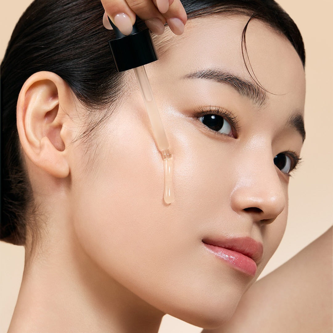 Woman applying MILK TOUCH Ginseng Gold PDRN Double Boosting Serum 30ml to her face for radiant skin.