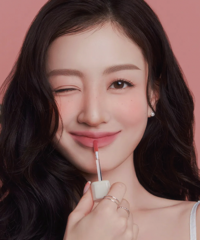 Woman applying MILK TOUCH Spread Fit Blur Tint with a smile