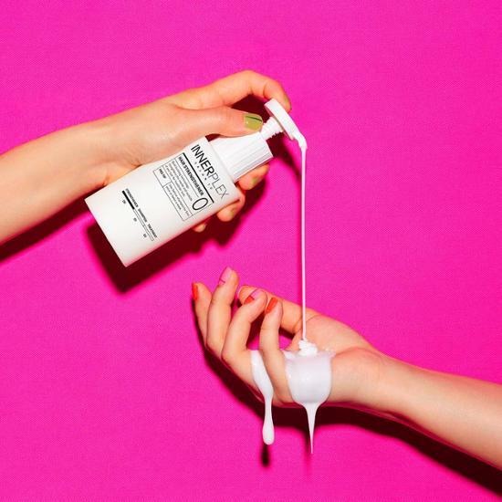 Hands pouring MISE EN SCENE Innerplex Hair Strengthening Shampoo 375g against pink background