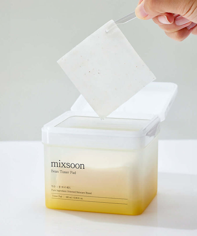 MIXSOON Bean Toner Pad being lifted from container, showcasing its texture.