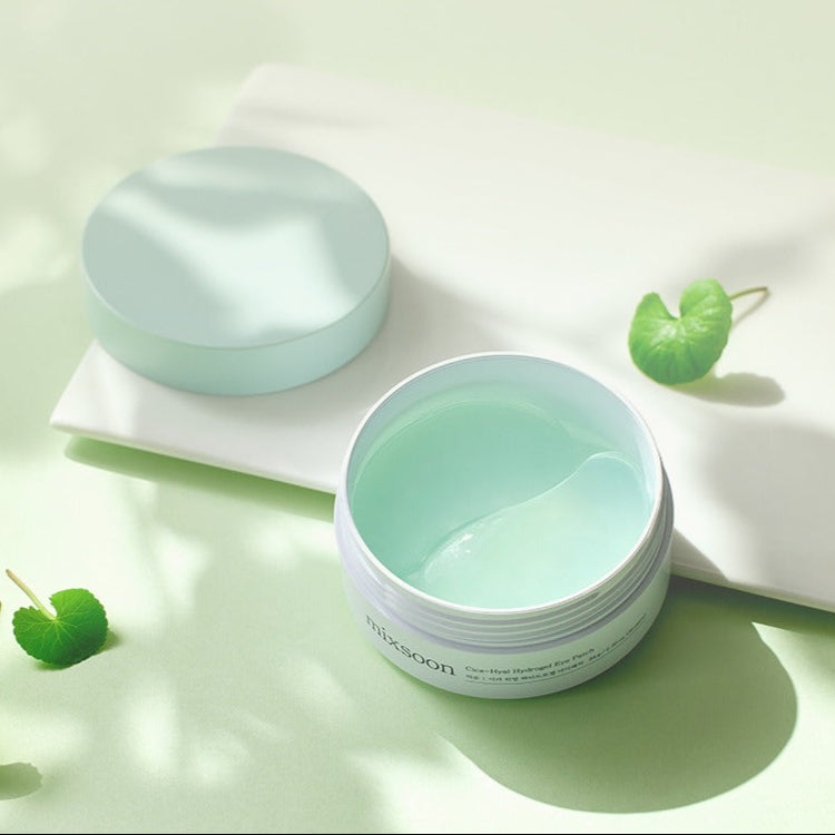MIXSOON Cica Hyal Hydrogel Eye Patch 60 Sheets in an open jar on a green background