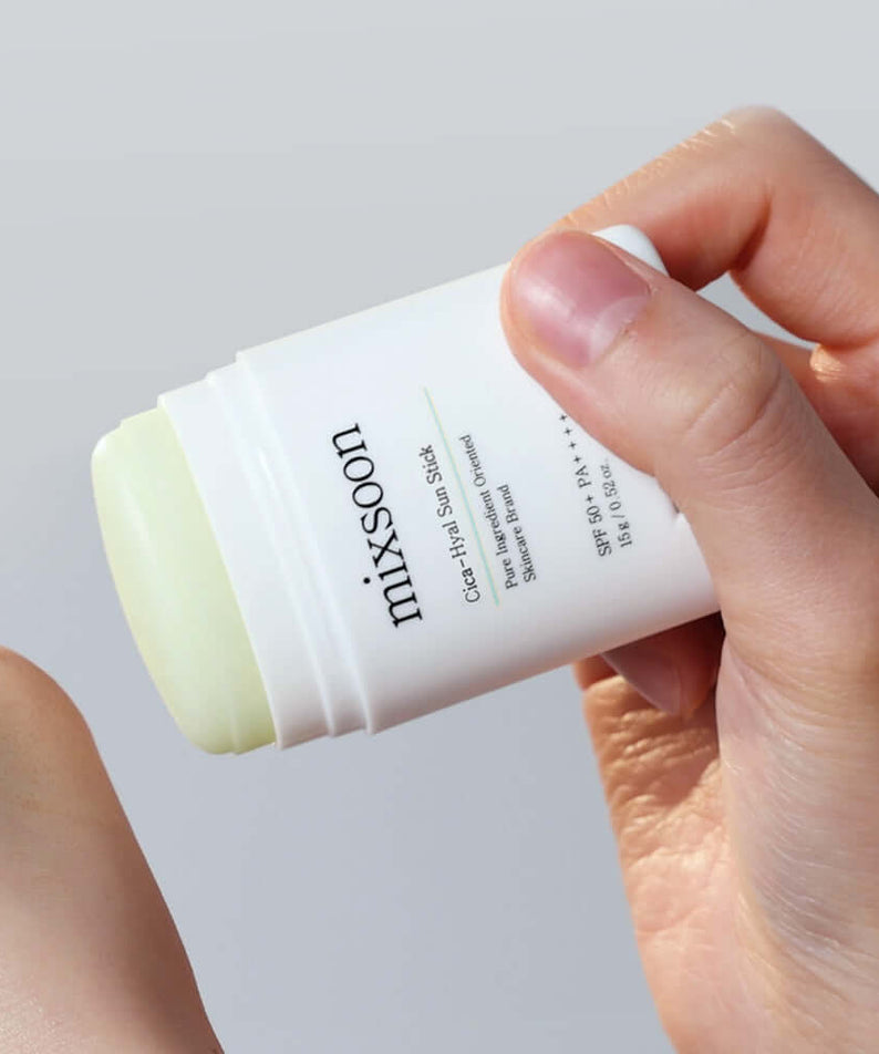 Hands holding MIXSOON Cica Hyal Sun Stick for skincare and sun protection