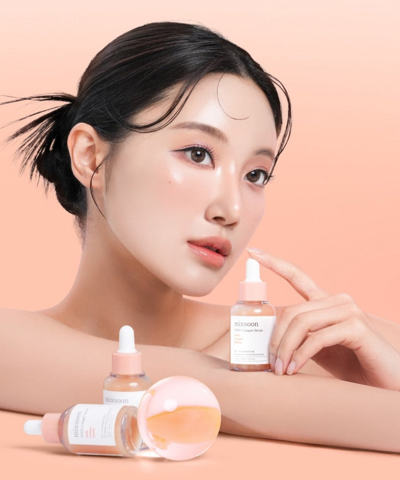 Woman holding MIXSOON PDRN Collagen Serum 30ml with additional bottles displayed against a peach background.