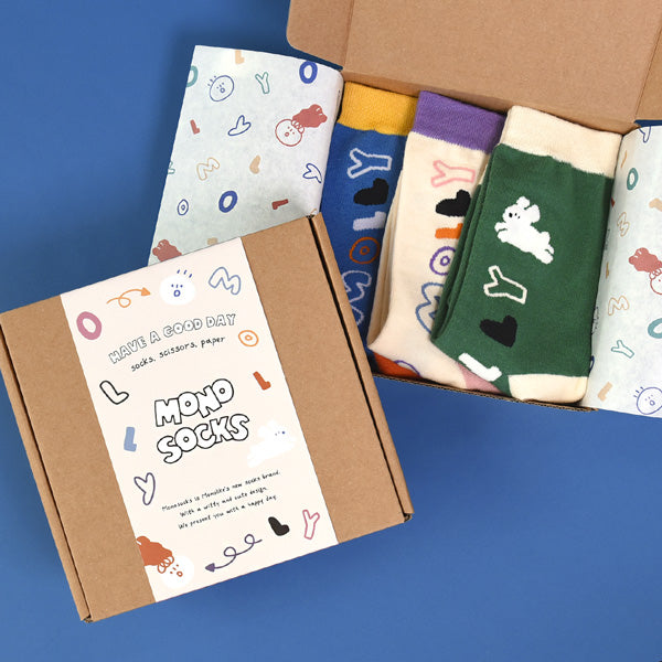 Colorful socks in a box with playful patterns, labeled as MONOLIKE Olly Molly - Initial Set.