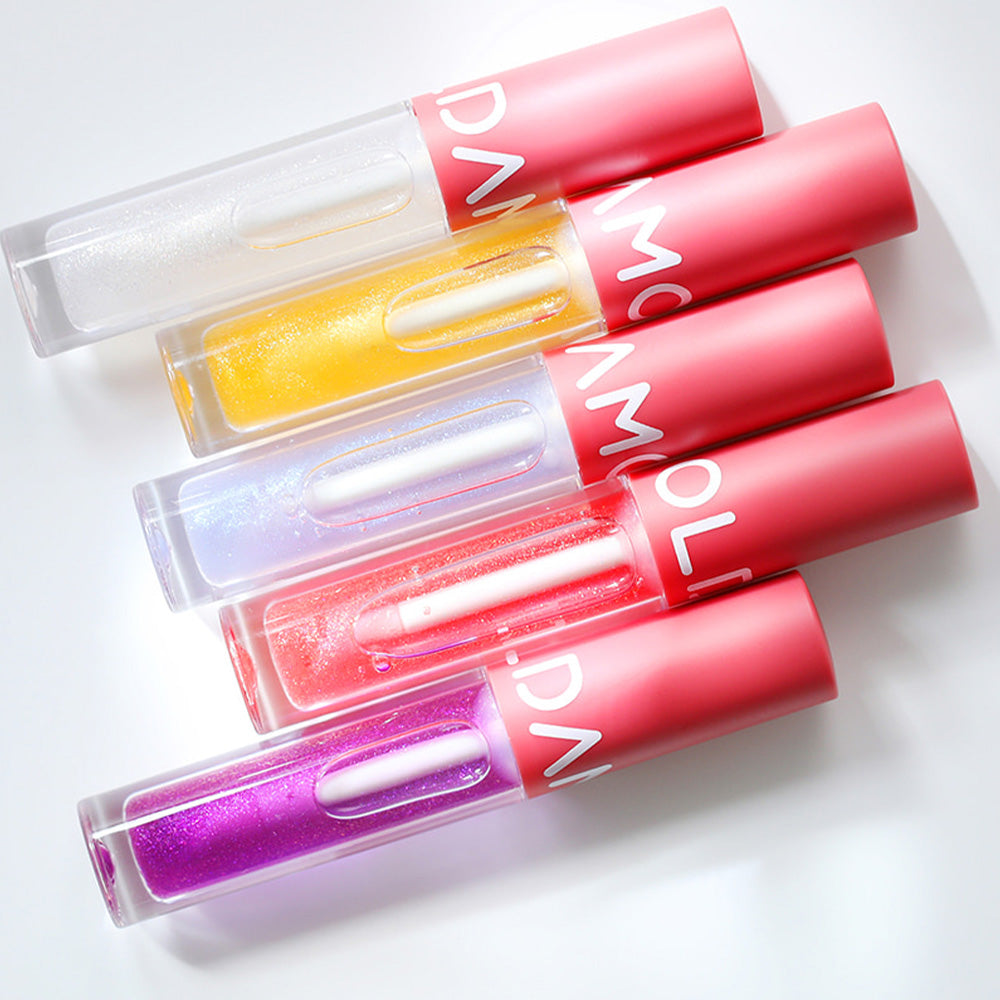 Colorful tubes of MOOLDA Volume Maxima Lip Plumper displayed in a flat lay arrangement.