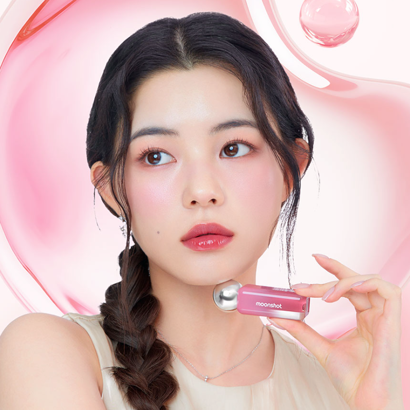 Model holding MOONSHOT Jelly Moon Glow Tint with pink glossy background showing vibrant lip color.