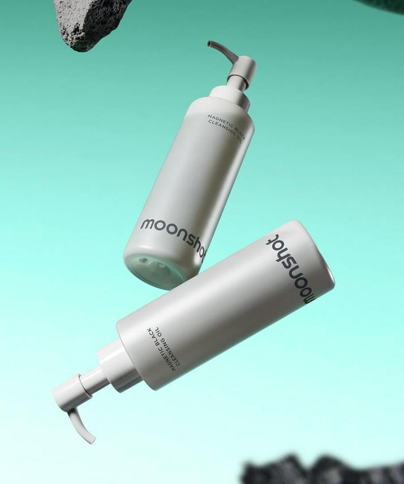 MOONSHOT Megnetic Black Cleansing Oil bottles floating in a turquoise background, displaying the product packaging and branding.