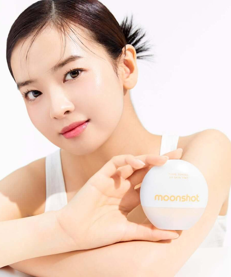 Woman holding MOONSHOT Tone Tuning UV Skin Tint SPF50+ PA++++ bottle