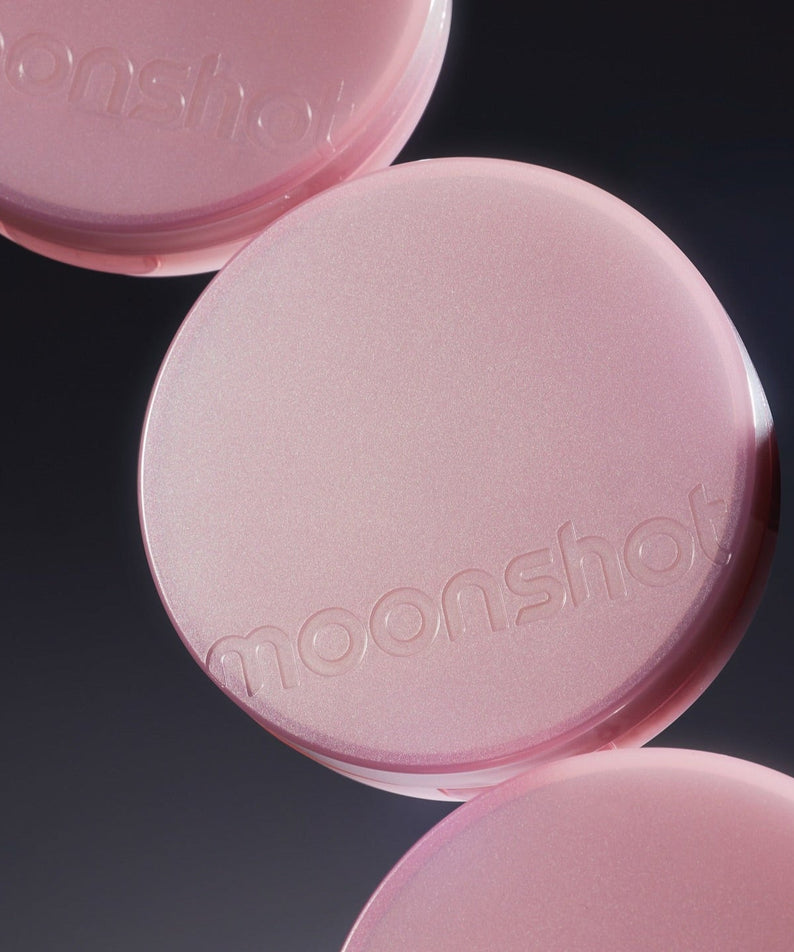 MOONSHOT Conscious Fit Cushion Foundation Pink Moon Edition compact case close-up on reflective surface.