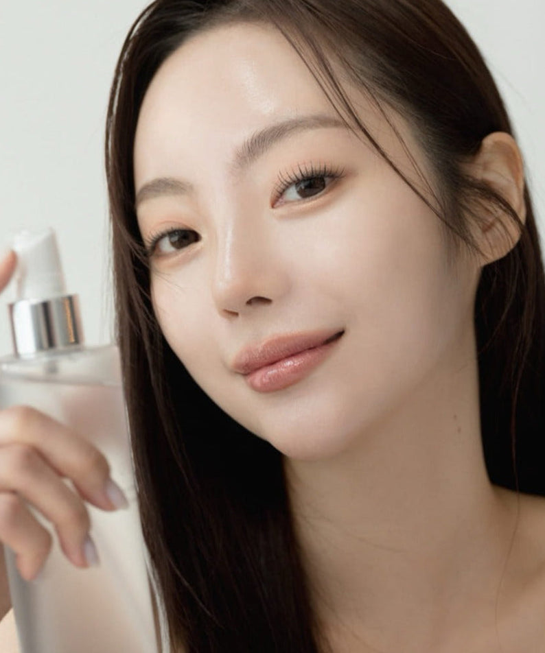 Woman using QUA-T Toner 200ml for skincare routine