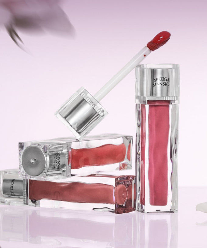 MUZIGAE MANSION Icy Glow Tint in elegant silver packaging on a pastel pink background, showcasing sleek design and vibrant color.