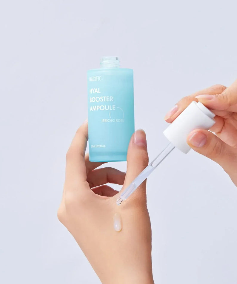 Applying NACIFIC Hyal Booster Ampoule 50ml with a dropper for skincare.
