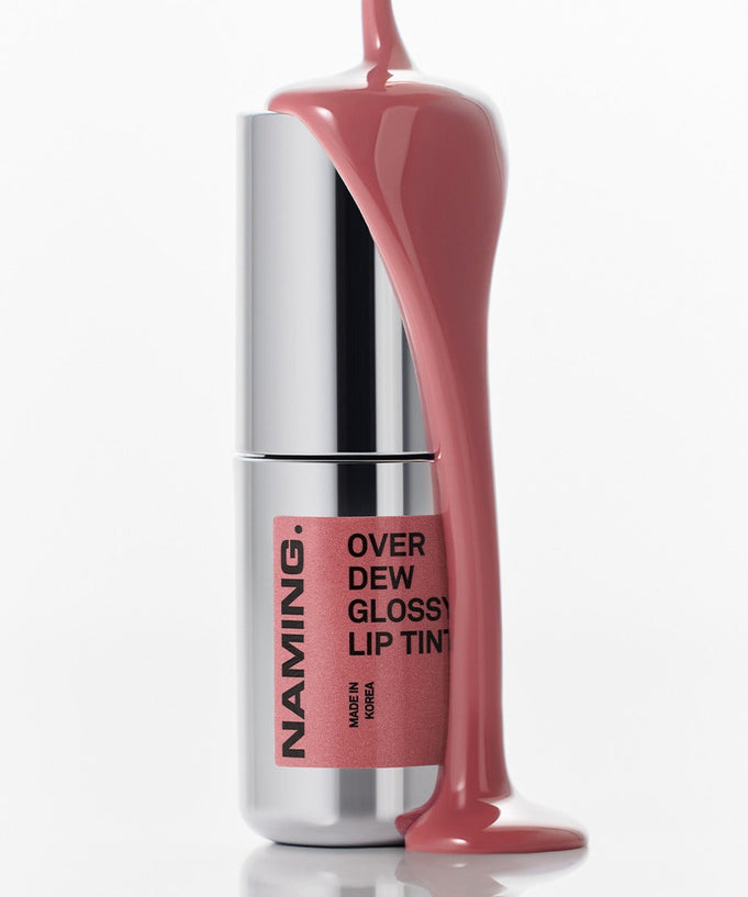 NAMING Overdew Glossy Lip Tint with pink tint flowing over silver tube, highlighting the product's shiny and sleek design.