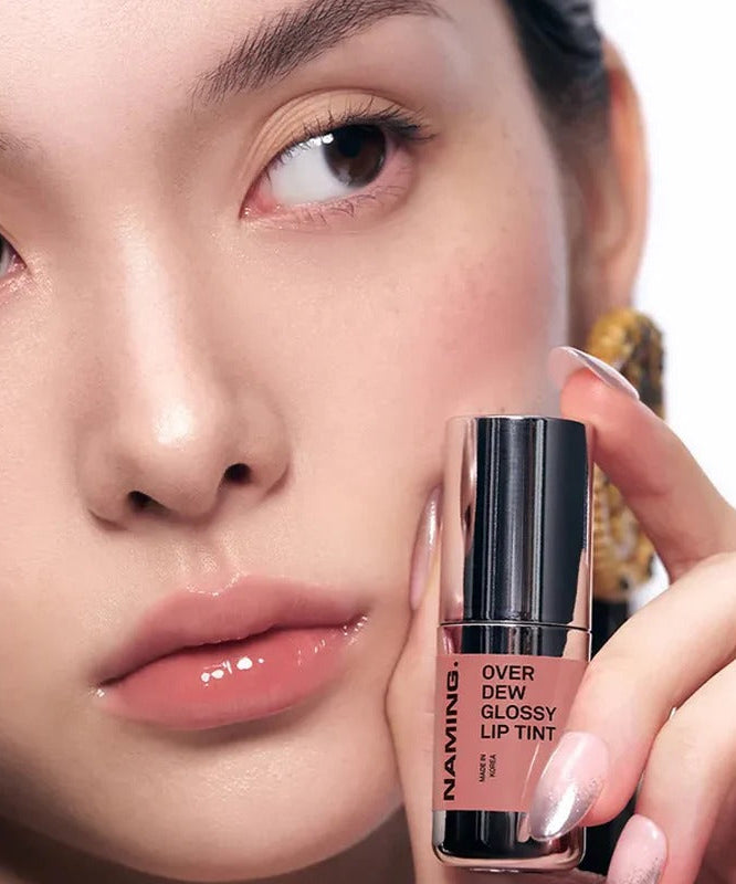Close-up of a person holding NAMING Overdew Glossy Lip Tint, showcasing a glossy natural lip tint shade for a radiant look.