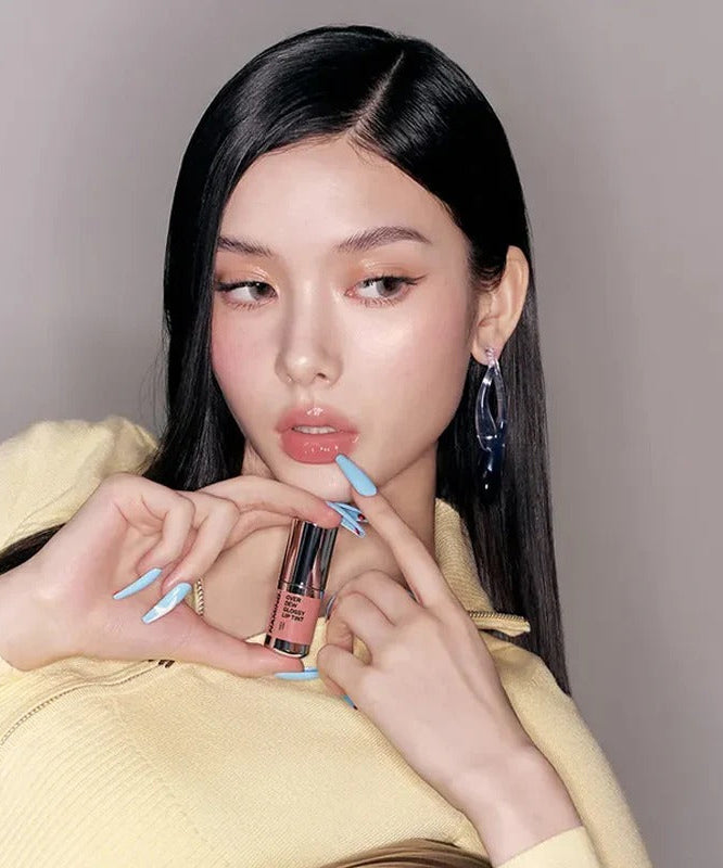Model showcasing NAMING Overdew Glossy Lip Tint with elegant nail art and sleek hair, highlighting the lip tint's vibrant shade.