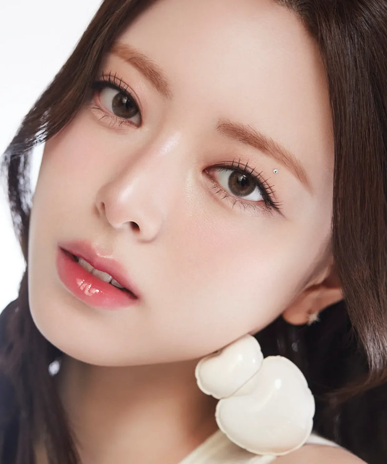 Model wearing NAMING Glow Heart Lip Tint with glossy lip finish.