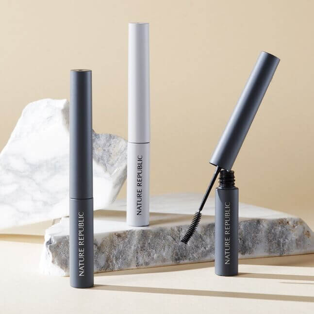NATURE REPUBLIC Botanical Superproof Mascara displayed on marble surface with packaging in stylish arrangement.