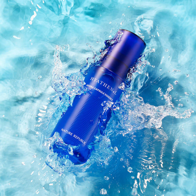 NATURE REPUBLIC Hyathenol Hydra Capsule Essence 50ml in blue bottle floating in water with splashes, highlighting skincare hydration