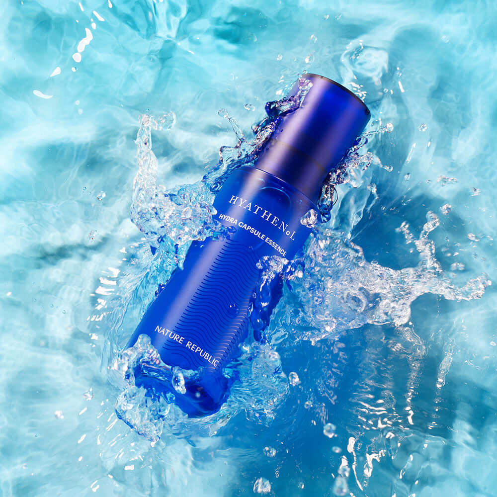 NATURE REPUBLIC Hyathenol Hydra Capsule Essence 50ml in blue bottle floating in water with splashes, highlighting skincare hydration