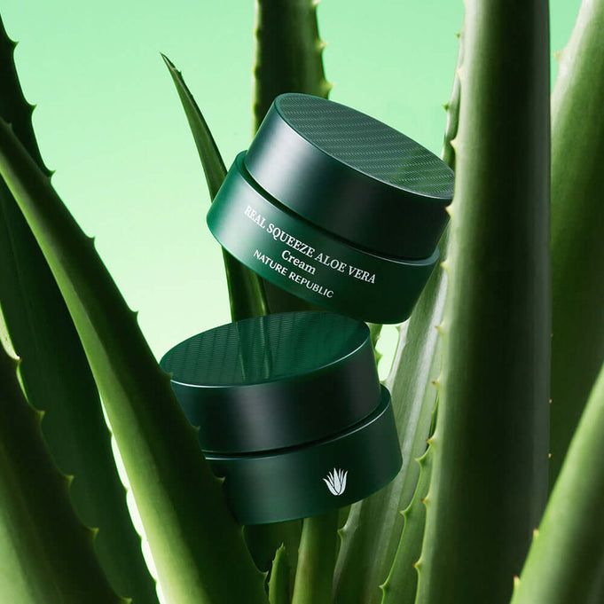 NATURE REPUBLIC Real Squeeze Aloe Vera Cream 55ml on aloe leaves, green background