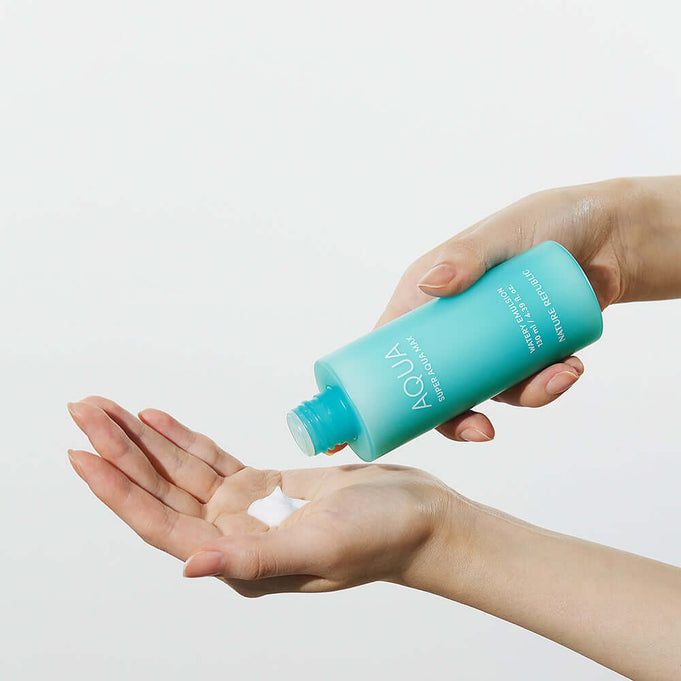 NATURE REPUBLIC Super Aqua Max Watery Emulsion 130ml being poured into a hand, showcasing the product's texture and viscosity.