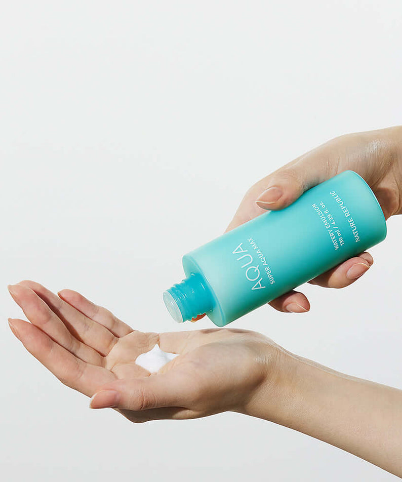NATURE REPUBLIC Super Aqua Max Watery Emulsion 130ml being poured into a hand, showcasing the product's texture and viscosity.