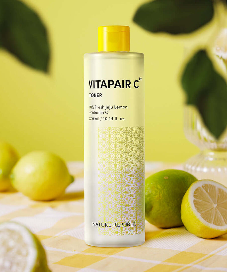 NATURE REPUBLIC VitaPair C Toner 300ml surrounded by fresh lemons on a table.