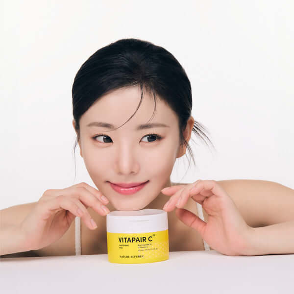 Woman with NATURE REPUBLIC Vitapair C Whitenning Pads 160ml smiling and holding product jar