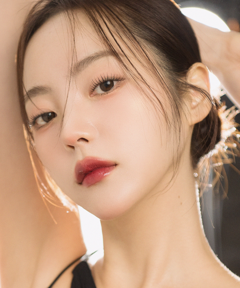 Model showcasing QUA-T The Glass Tattoo Tint with flawless makeup and smooth skin.