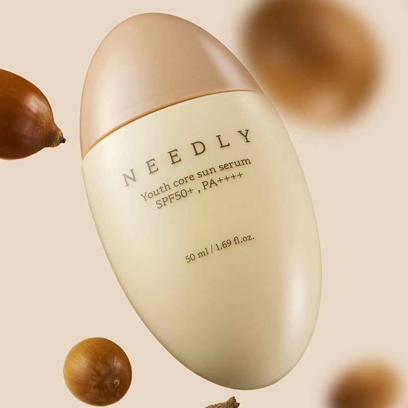 NEEDLY Youth Core Sun Serum 50ml bottle with SPF 50+ and PA++++, surrounded by natural elements. Ideal for skincare protection.