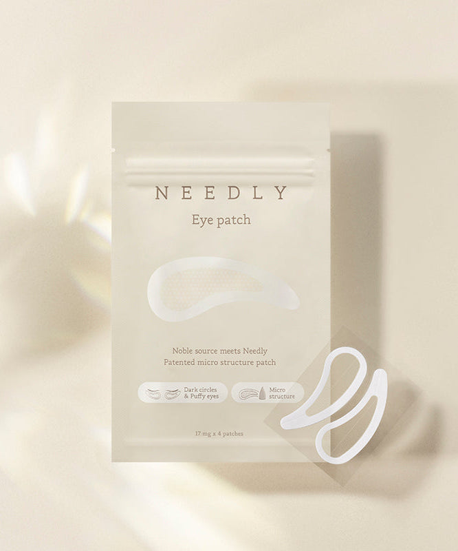 NEEDLY Eye Patch packaging with patches displayed on a light background, highlighting the product benefits for dark circles and microstructure innovation.