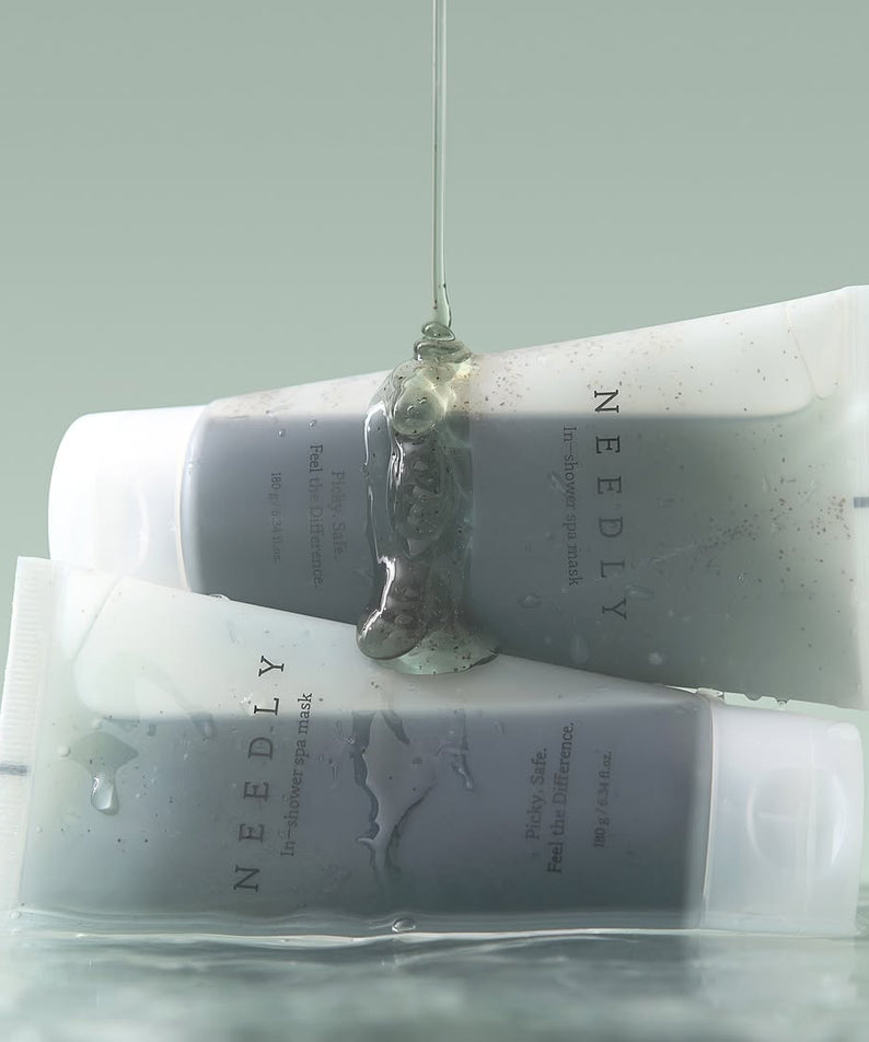 Two tubes of NEEDLY Ishower Spa Mask 180g with water droplets, showcasing moisturizing spa treatment.