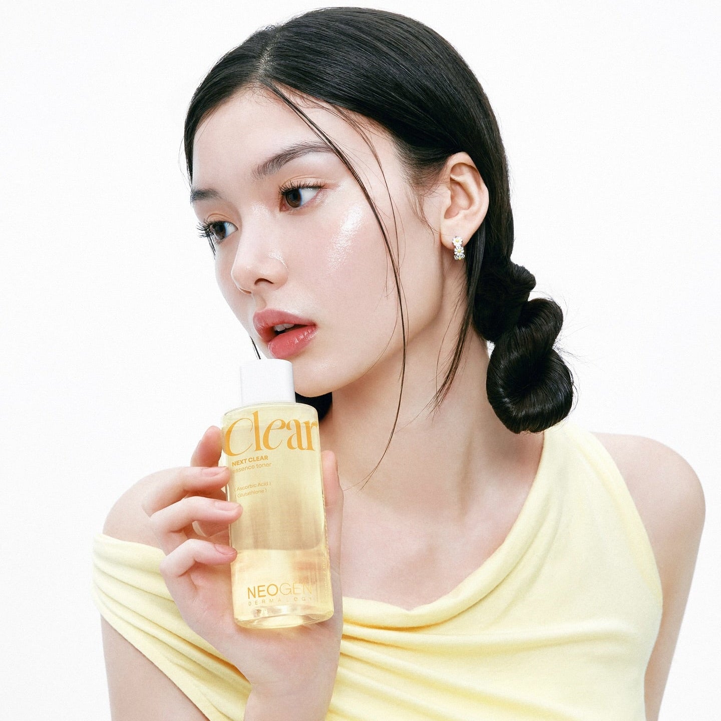 Woman holding NEOGEN Next Clear Essence Toner 210ml with glowing skin