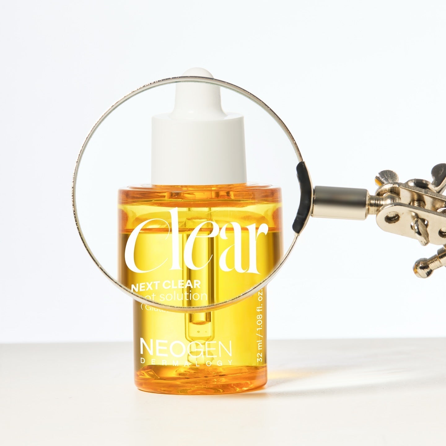 NEOGEN Next Clear Spot Solution 32ml with magnifying glass highlighting product details.