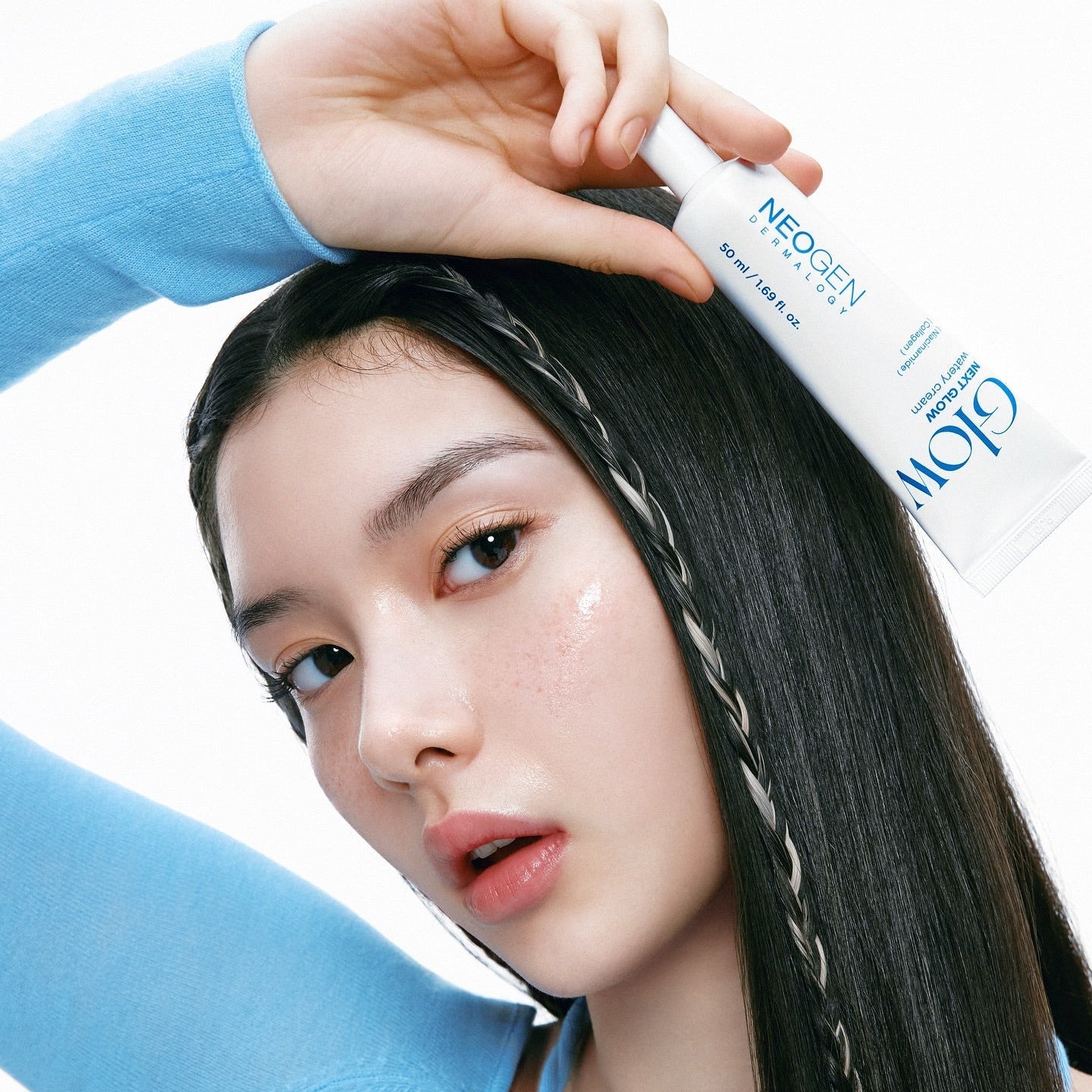 Woman holding NEOGEN Next Glow Moisture Cream 50ml against her face.