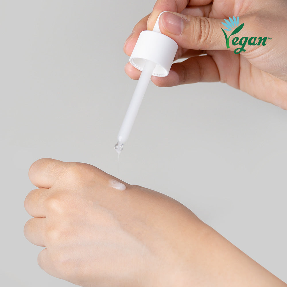 Applying NEOGEN Real Niacinamide 15% Serum 30ml with dropper onto hand, vegan skincare product.
