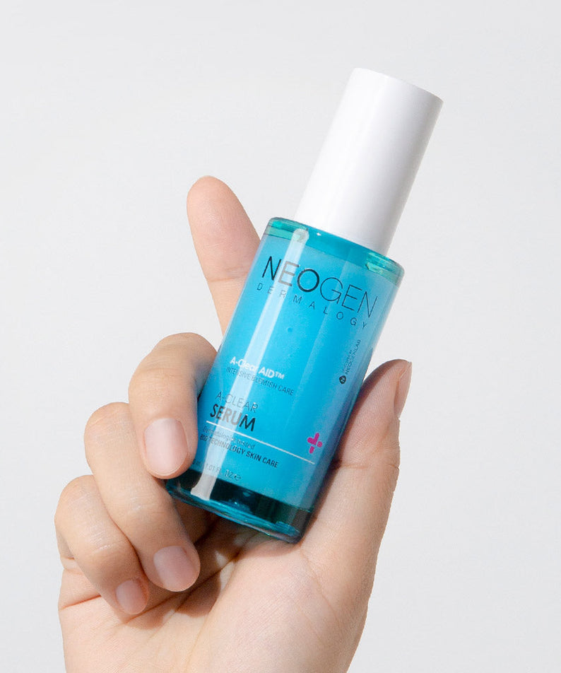 Hand holding NEOGEN A Clear Serum 30ml bottle showcasing skincare product design and label.