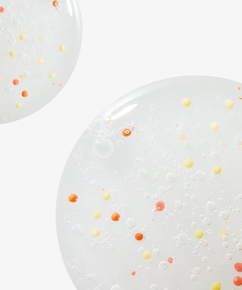 Close-up of NEOGEN Dounble Viita Capsual Cleansing Foam 150ml texture with vibrant orange and yellow capsules on a white background.