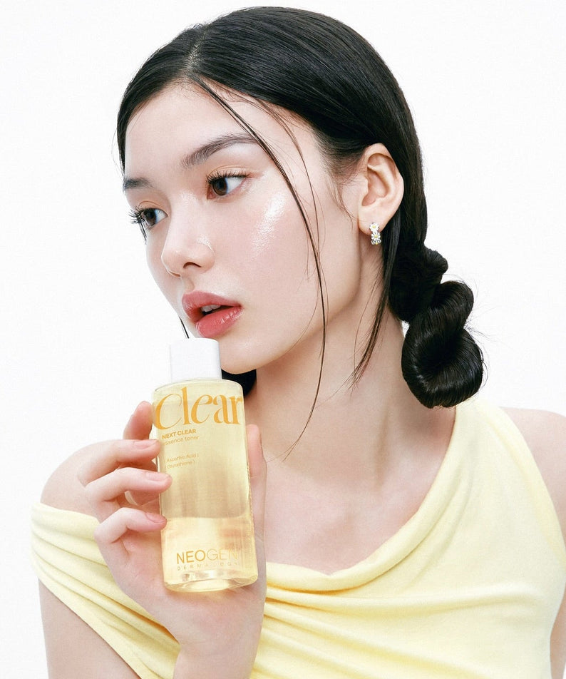 Woman holding NEOGEN Next Clear Essence Toner 210ml with glowing skin